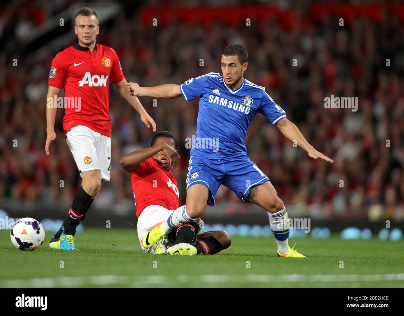 Manchester United's Antonio Valencia slides in on Chelsea's Eden Hazard Stock Photo