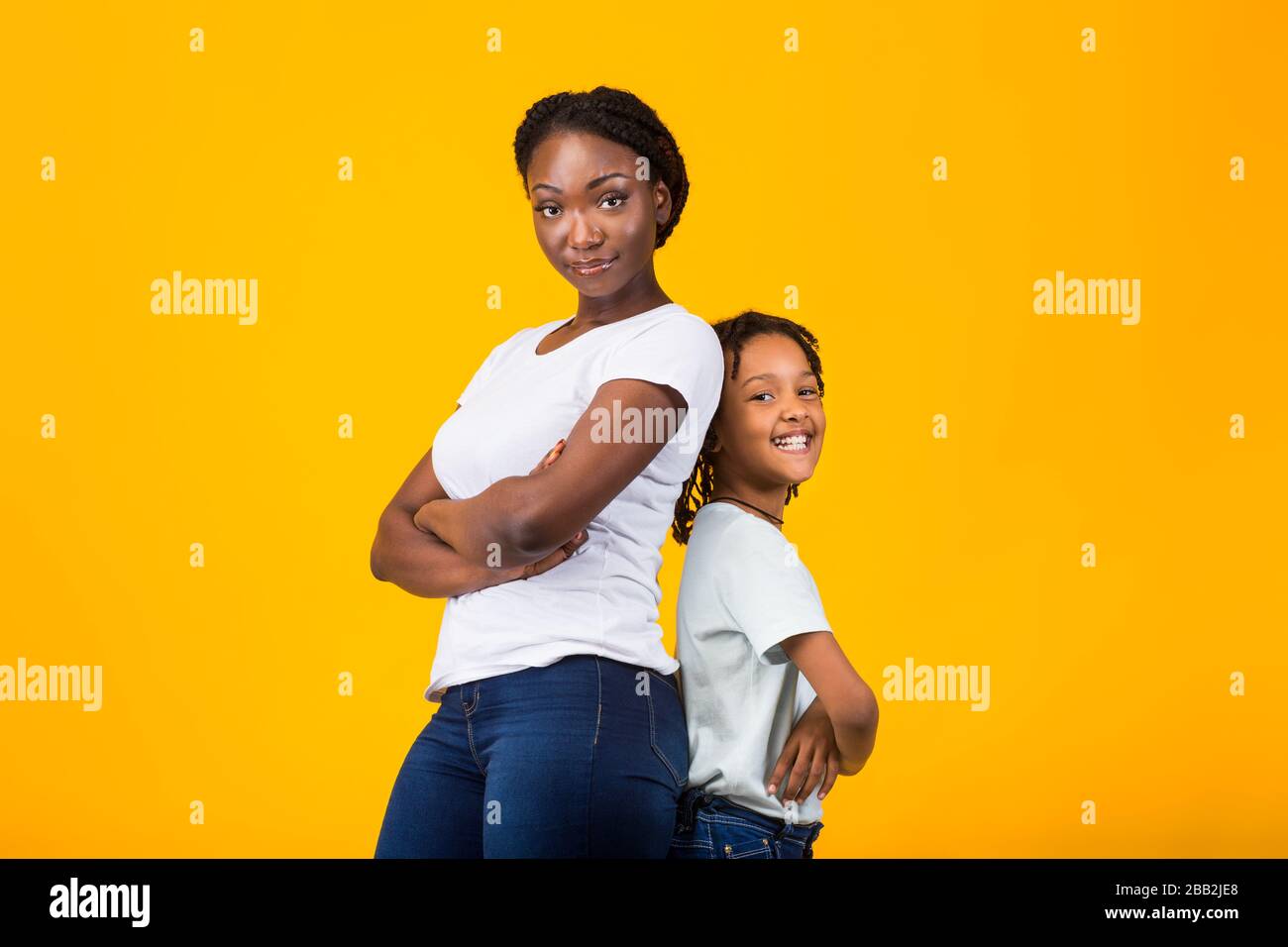 Black mother standing back to back with her kid Stock Photo Alamy