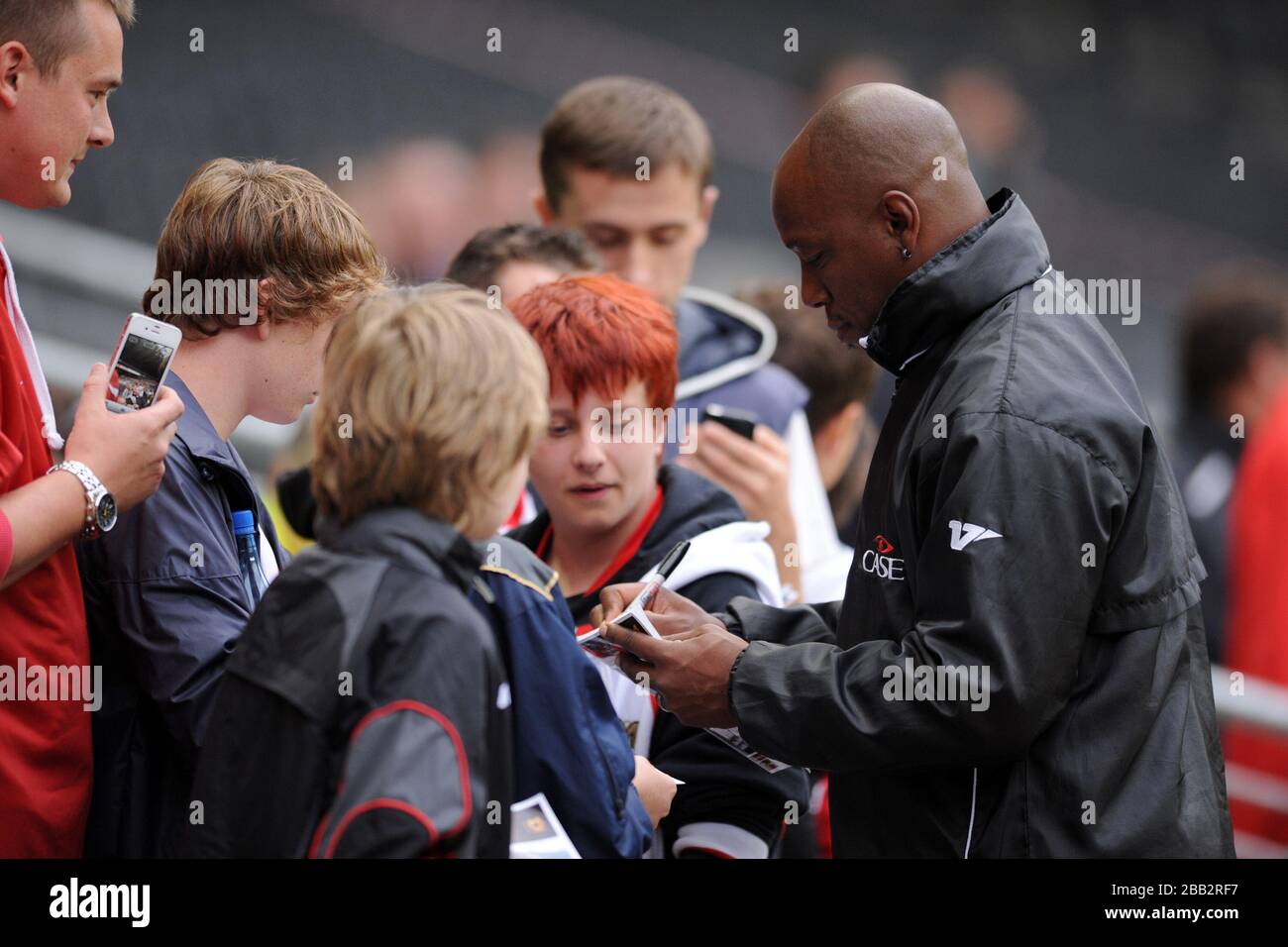 Milton Keynes Dons' First team Coach Ian Wright signs autographs for