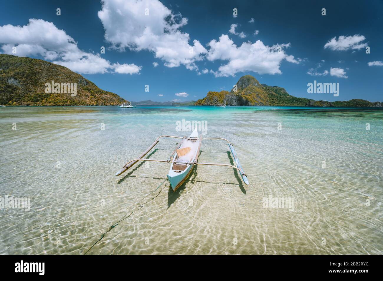 El Nido bay. Palawan island, Philippines. Lonely filippino fishing boat in shallow water lagoon at noon. Travel exotic Stock Photo