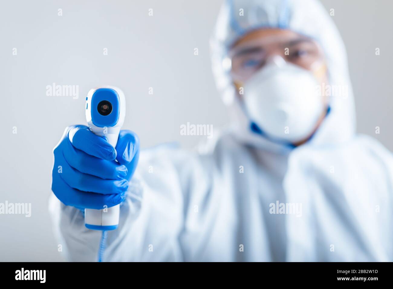 Asian man directs infrared thermometer on camera Stock Photo