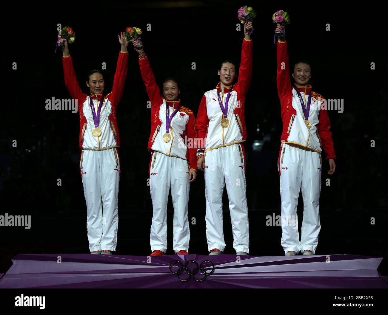 Members of China's epee fencing team celebrate their gold medal in the