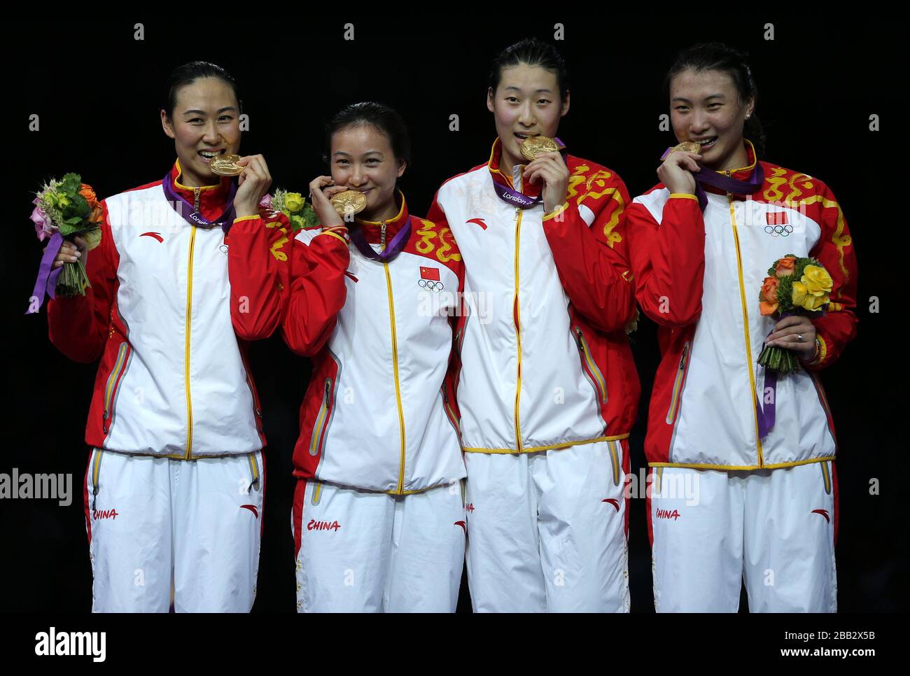 Members of China's epee fencing team celebrate their gold medal in the