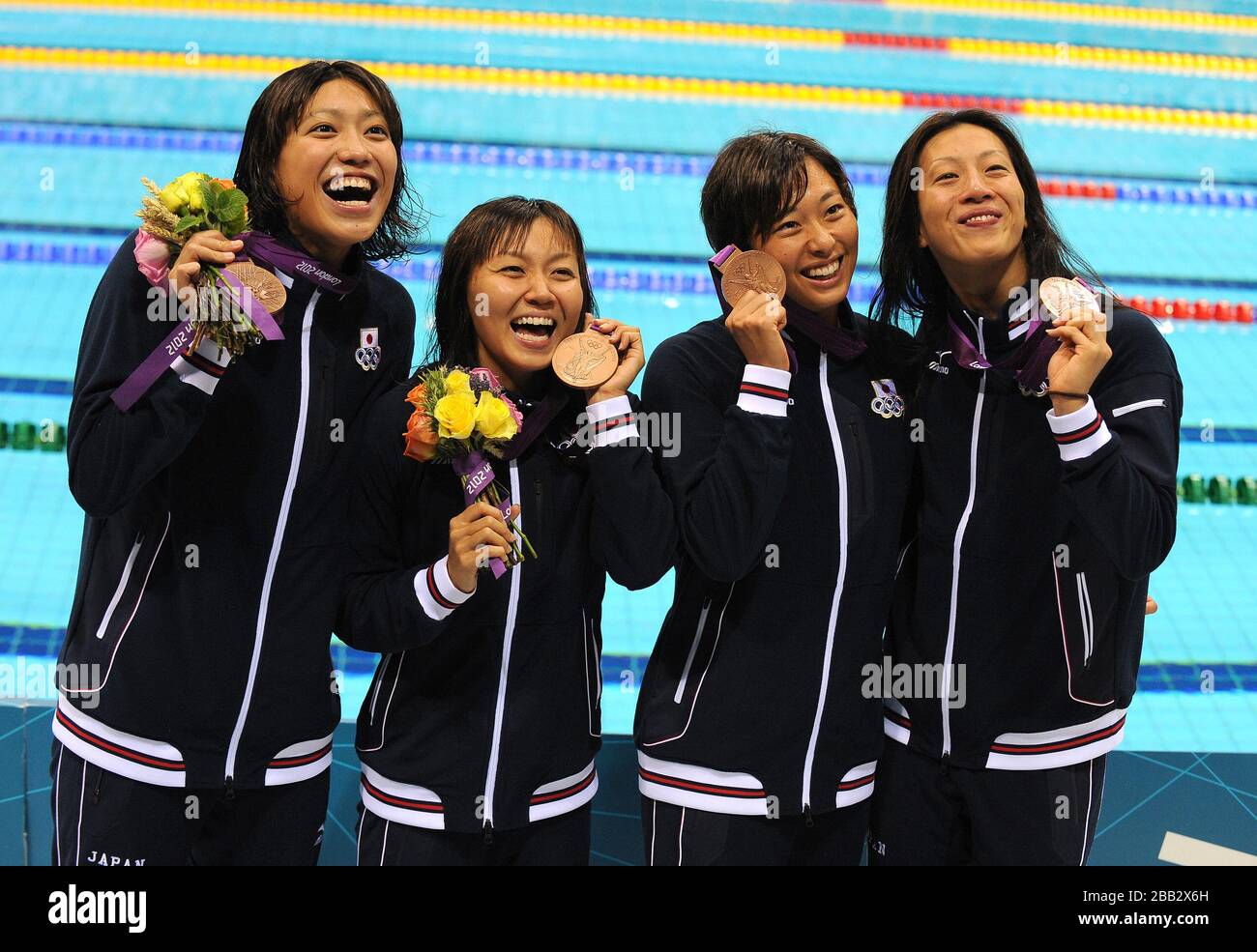Japan's Women's 4x100m relay team Aya Terakawa, Satomi Suzuki, Yuka Kato and Haruka Ueda (right to left) celebrate with their Bronze medals at The Aquatic Centre Stock Photo