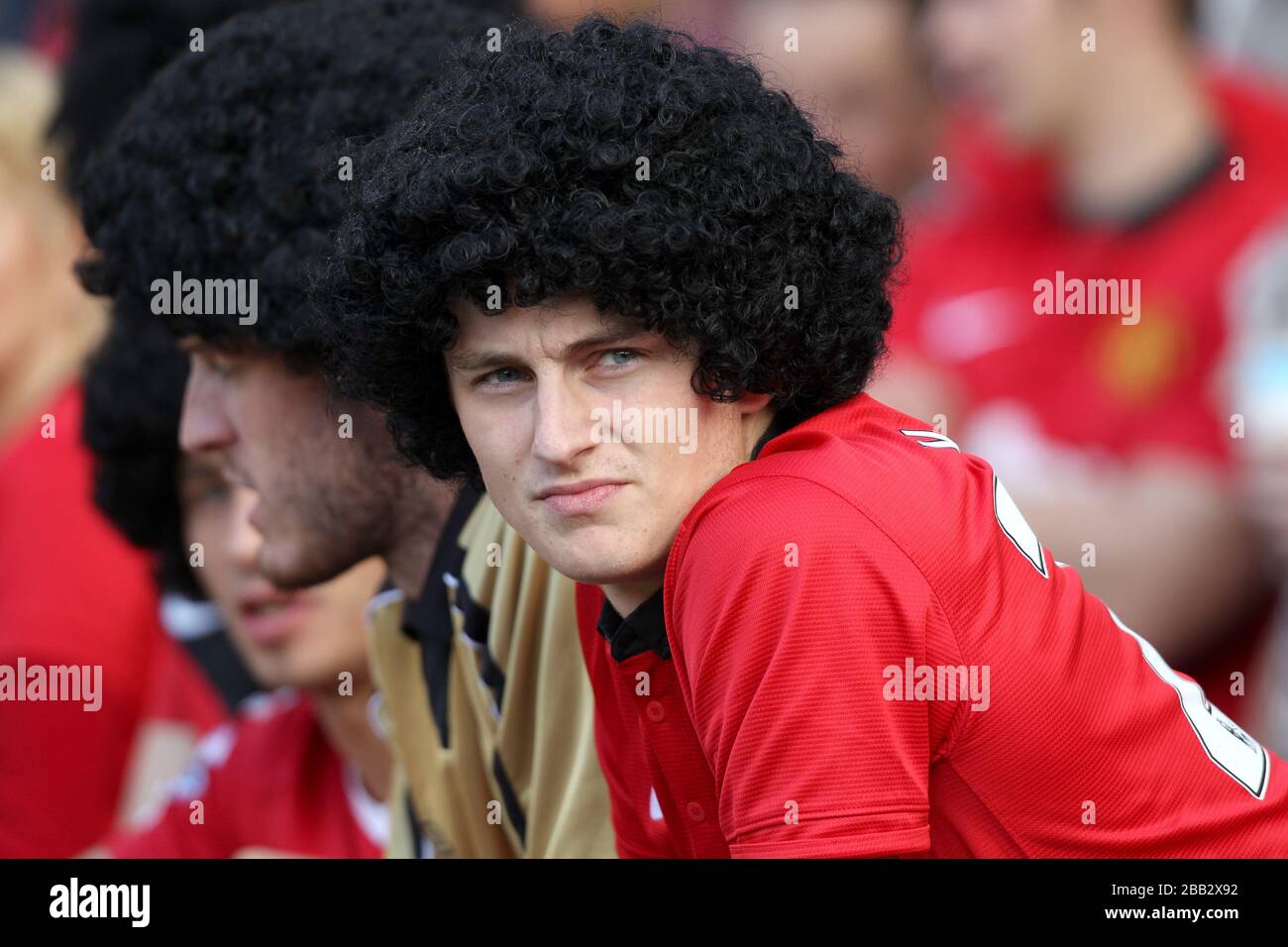 A Manchester United fan wears a wig imitating Marouane Fellaini in the stands Stock Photo