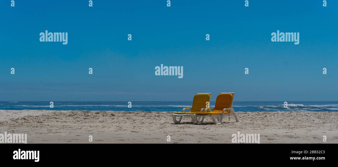 Beach scene with two empty beach benches. Selective focus. Stock Photo