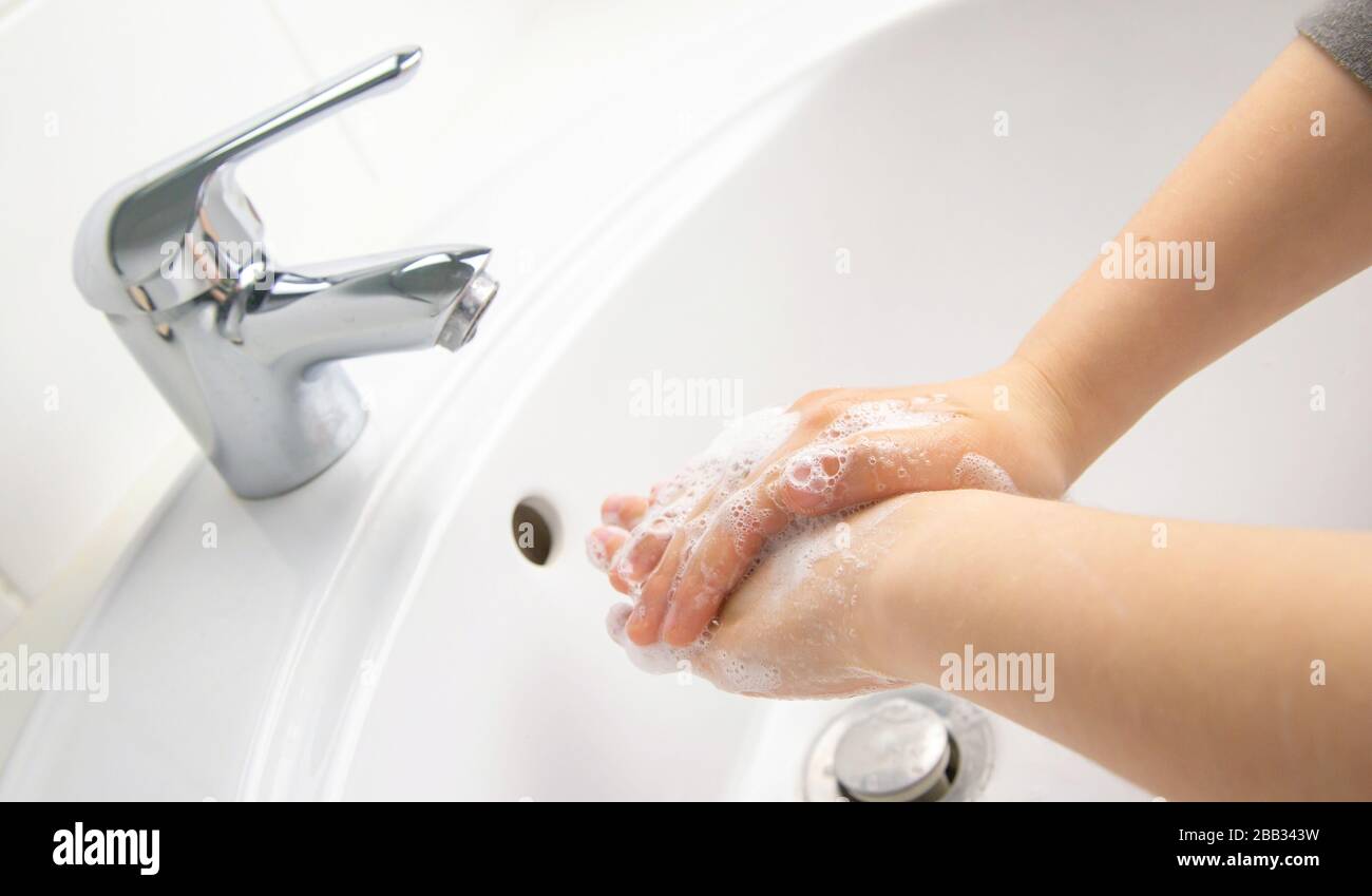 Kid cleaning and washing hands with soap in the bathroom Stock Photo ...