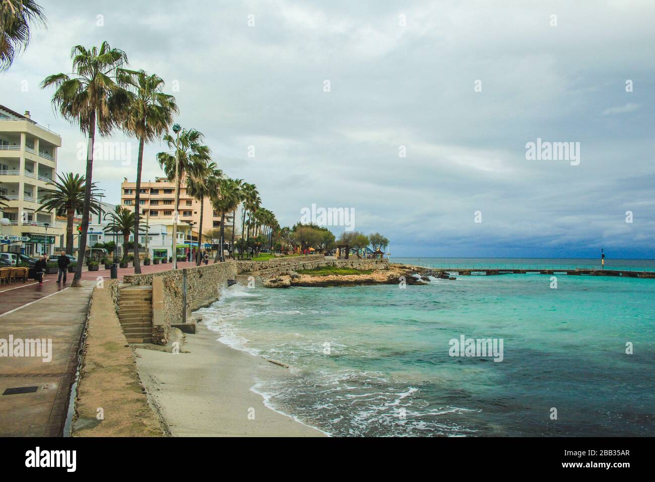 Cala Millor, Mallorca / Spain - March 24 2018: Only a few people walking along the promenade in Cala Millor, which is a famous tourist spot in summer Stock Photo