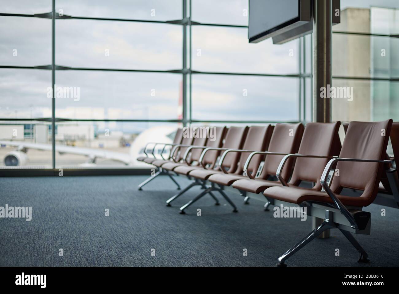 Empty airport with blurred plane and cloudy tragik sky on a background Stock Photo