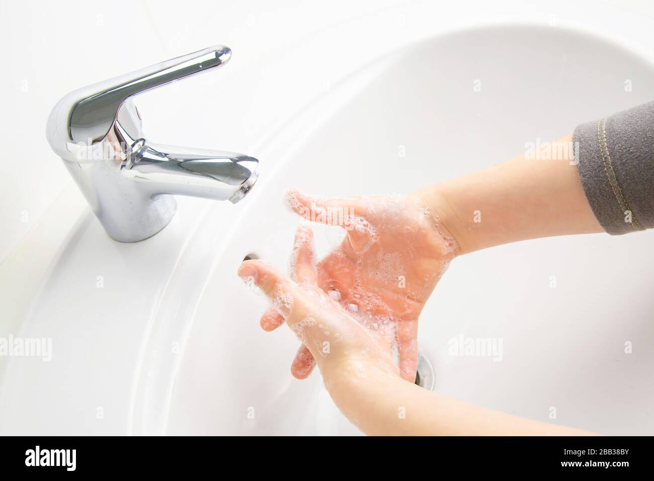 Kid cleaning and washing hands with soap in the bathroom Stock Photo ...