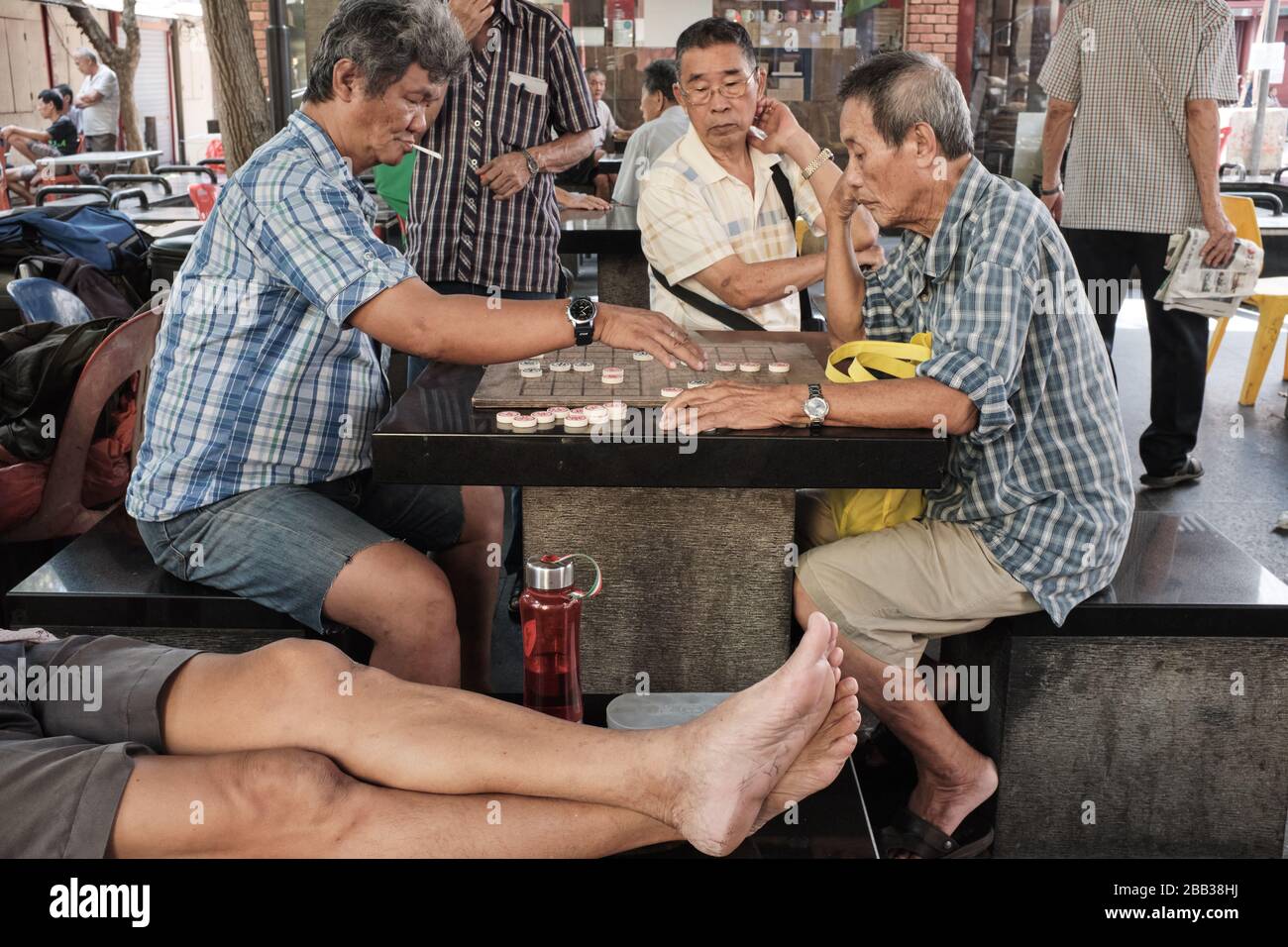 Elderly Singaporean men passing their time by playing a kind of Chinese ...