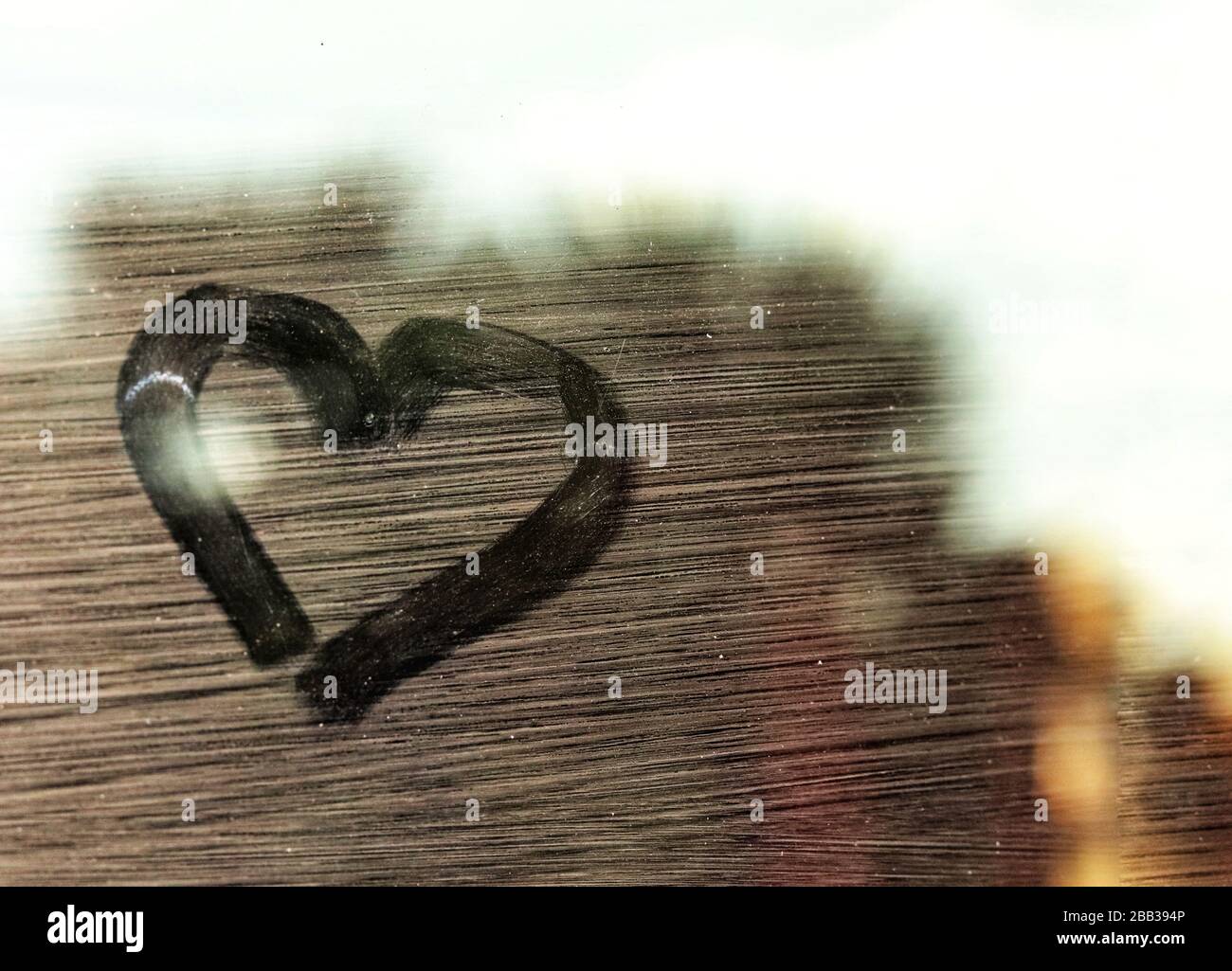 Heart drawing on a glass window showing concept of the struggle to cope with depression during home quarantine and social distancing Stock Photo