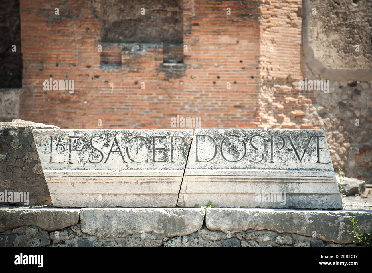 Latin inscription that once formed part of the marble portico that ran around the top of the colonnade of the Forum in Pompeii, Italy Stock Photo