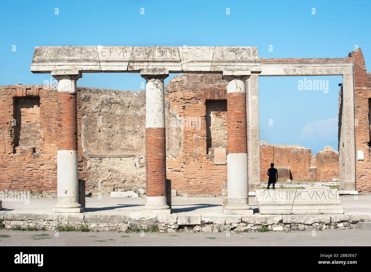 A tourist stands in the doorway of the Building of Eumachia, Pompeii, Italy Stock Photo