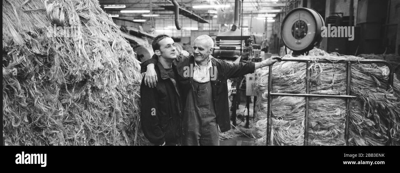 Two workers enjoying a joke together at Tay Spinners mill in Dundee, Scotland. This factory was the last jute spinning mill in Europe when it closed for the final time in 1998. The city of Dundee had been famous throughout history for the three 'Js' - jute, jam and journalism. Stock Photo