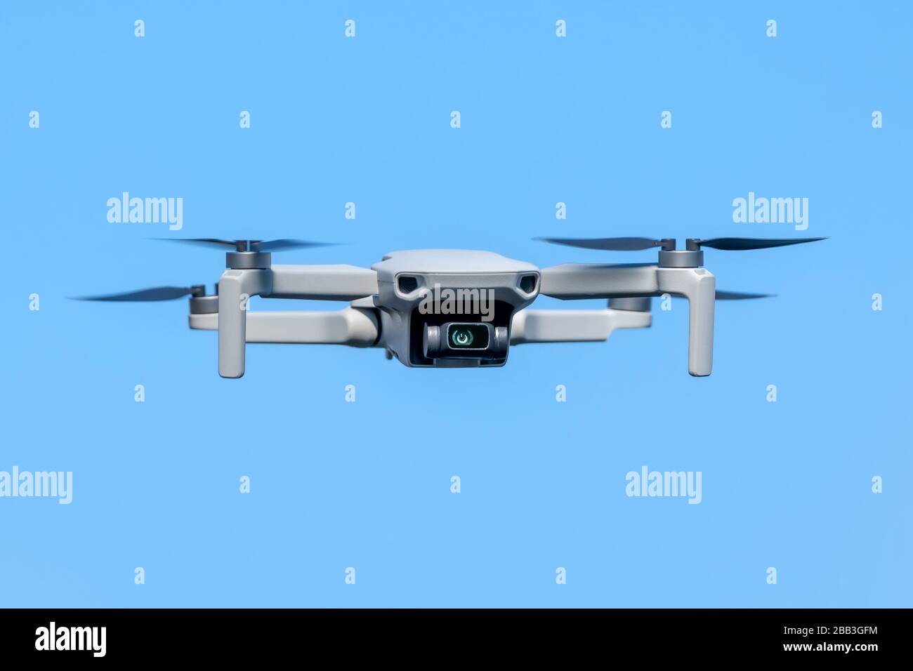 Drone Quadcopter during flight on a sunny day on blue sky background Stock Photo