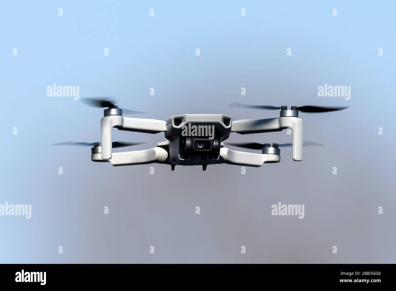 Drone Quadcopter during flight on a sunny day on blue sky background Stock Photo
