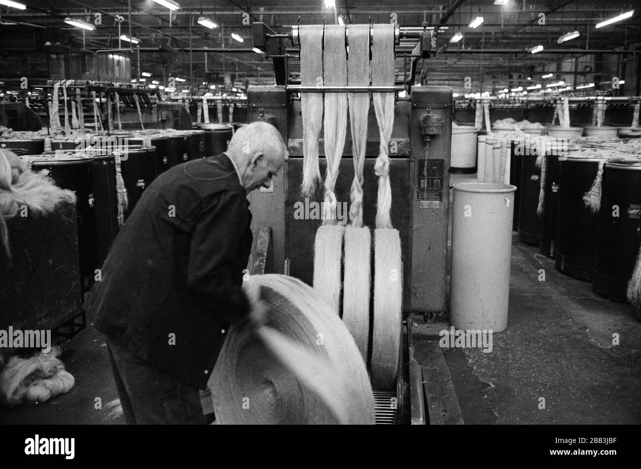 A worker with circular rolls of jute at Tay Spinners mill in Dundee, Scotland. This factory was the last jute spinning mill in Europe when it closed for the final time in 1998. The city of Dundee had been famous throughout history for the three 'Js' - jute, jam and journalism. Stock Photo