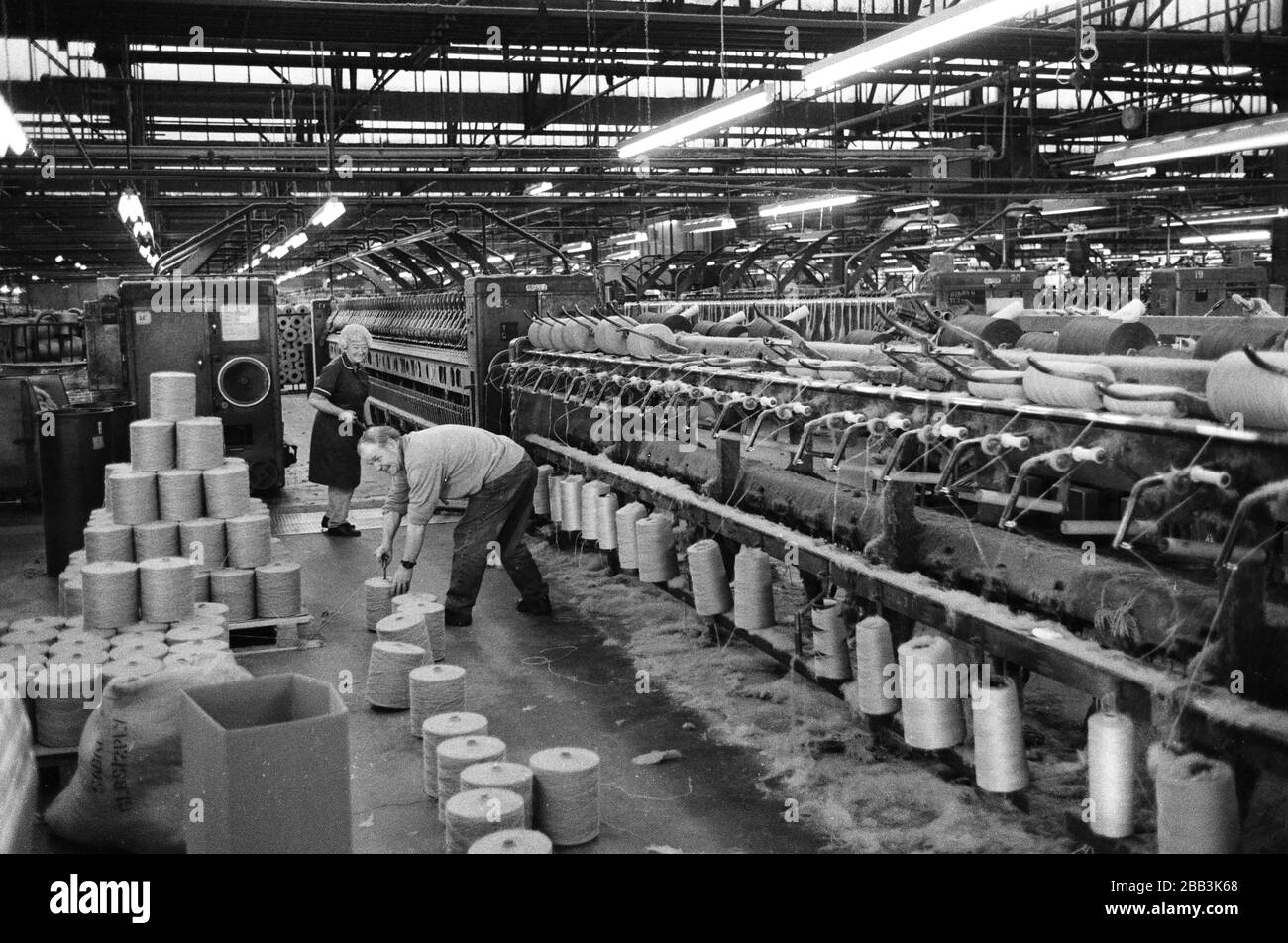 Two workers supervising a machine at Tay Spinners mill in Dundee, Scotland. This factory was the last jute spinning mill in Europe when it closed for the final time in 1998. The city of Dundee had been famous throughout history for the three 'Js' - jute, jam and journalism. Stock Photo