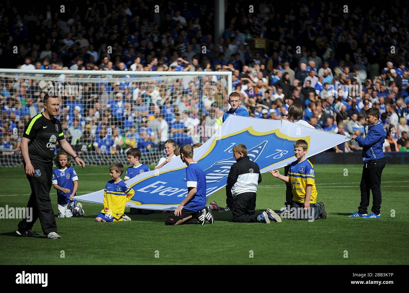 Children hold up a banner of the Everton club crest at Goodison Park ...