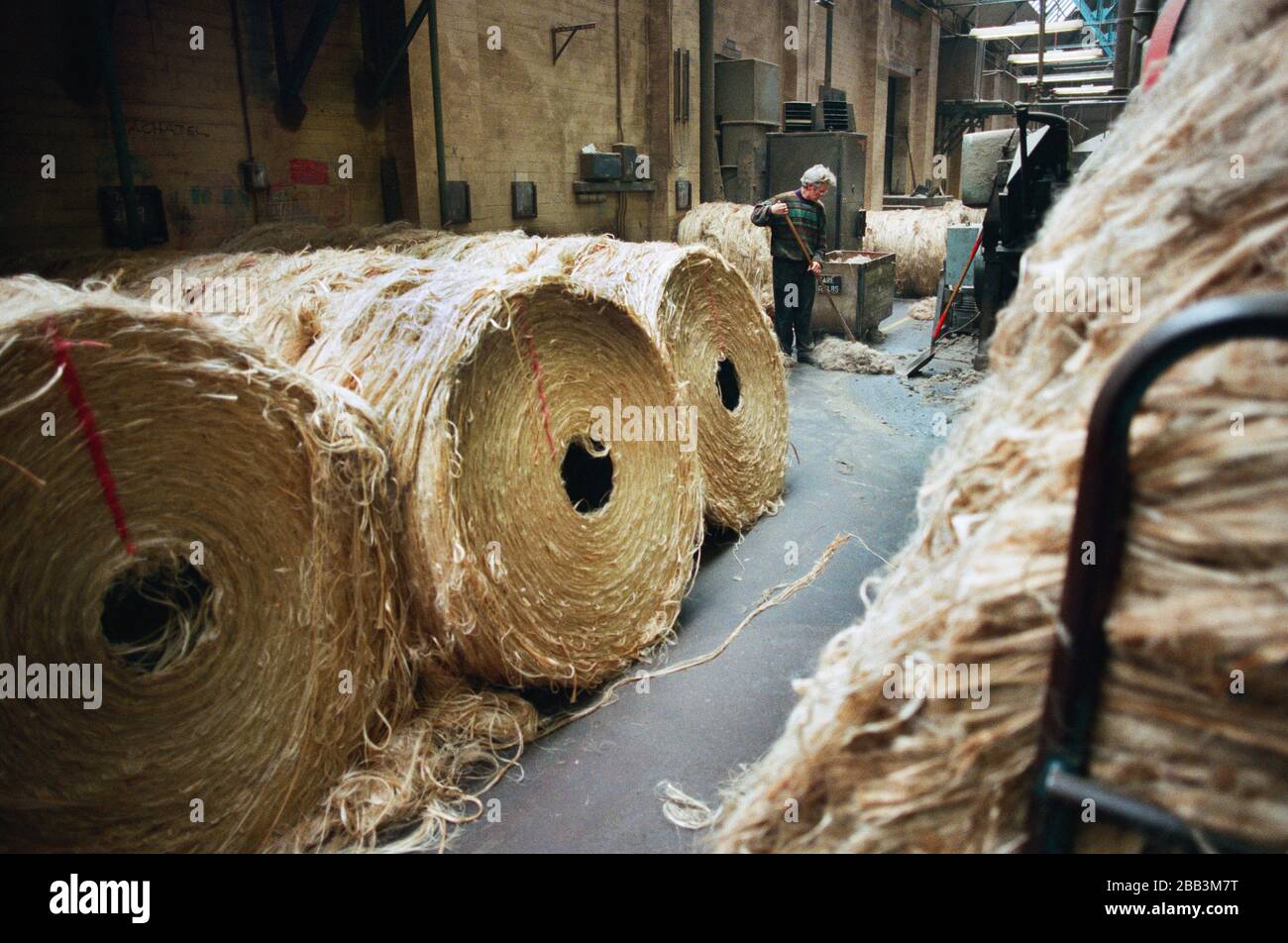 A worker sweeping the factory floor at Tay Spinners mill in Dundee, Scotland. This factory was the last jute spinning mill in Europe when it closed for the final time in 1998. The city of Dundee had been famous throughout history for the three 'Js' - jute, jam and journalism. Stock Photo