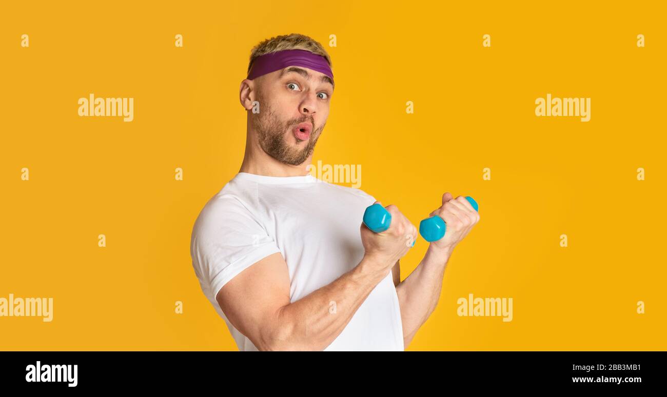 Man blowing lips and funny engaged with small dumbbells Stock Photo