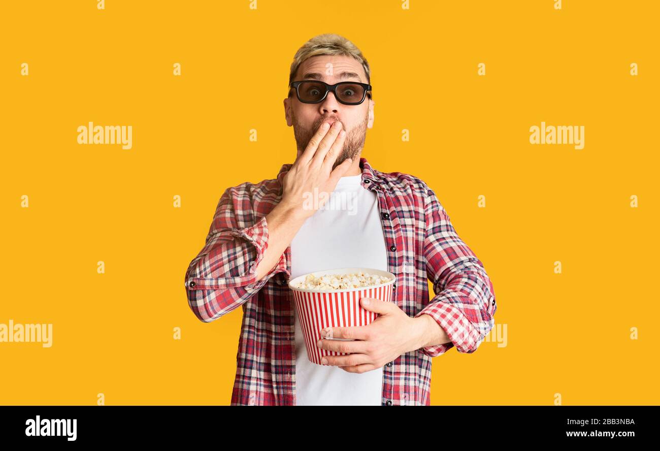 Guy in 3D glasses covers mouth with hand Stock Photo