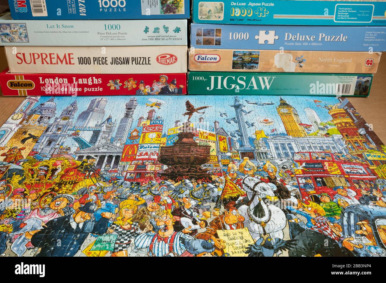 Completed jigsaw puzzle and stack of jigsaw puzzles in boxes Stock Photo