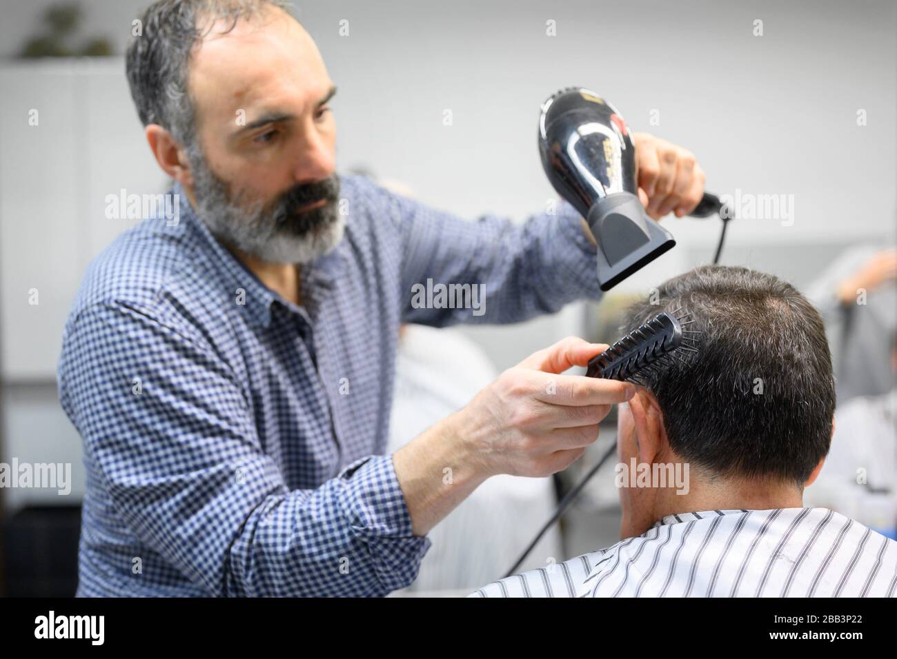 Barber trimming hair of old man at barber shop Stock Photo Alamy