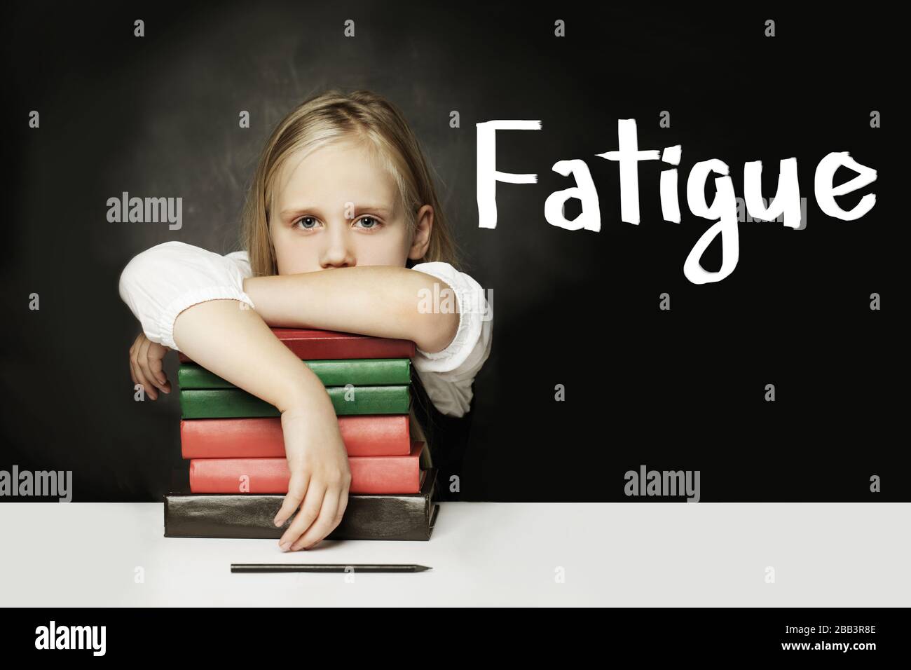 Sad Tired child girl with books. Fatigue concept Stock Photo