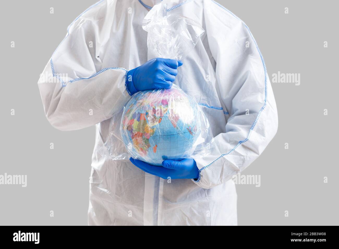 World epidemic danger. Man in protective suit holds globe in oilcloth bag Stock Photo