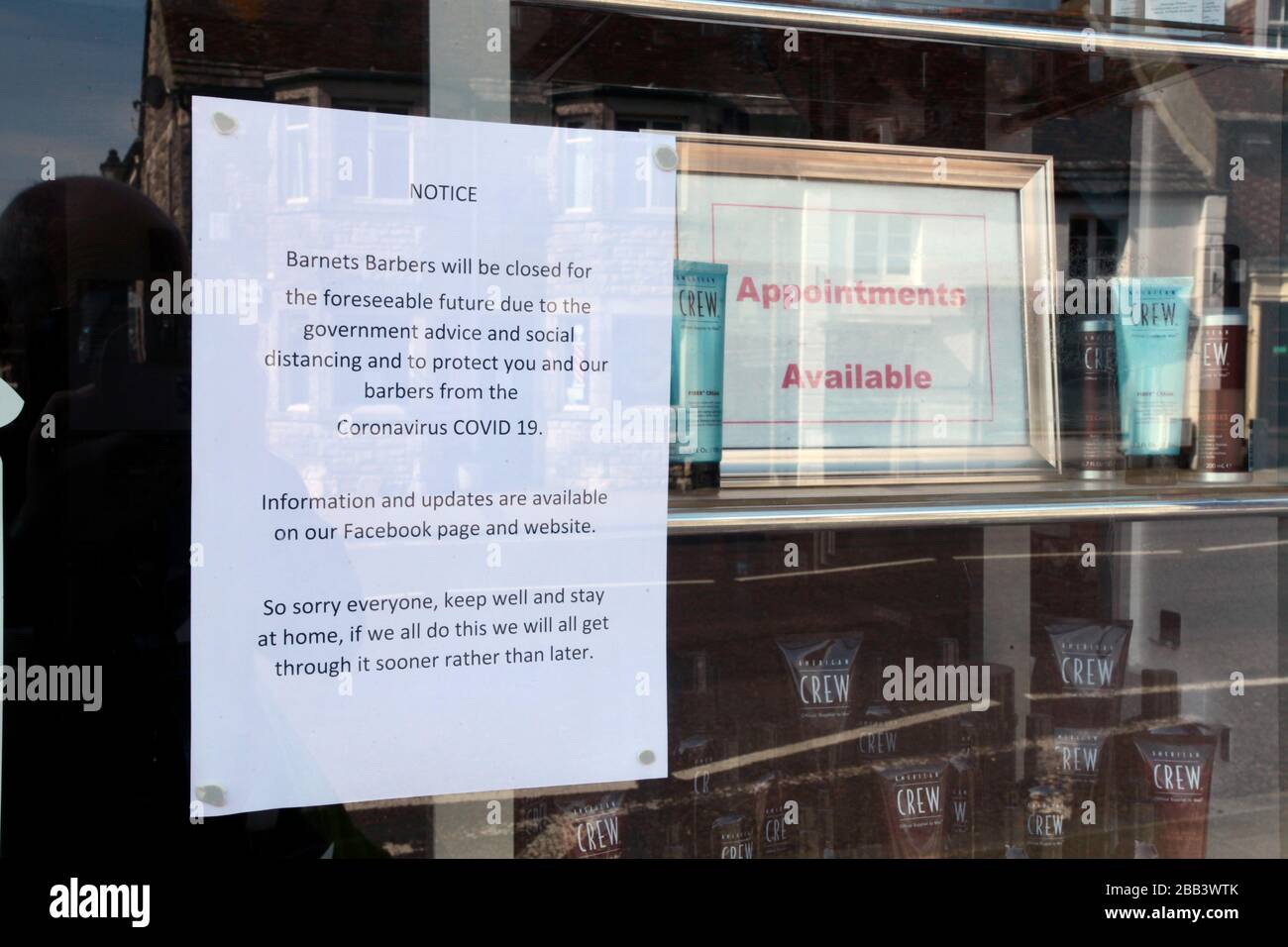 Covid 19 Sign in a closed hairdressers window in a market Town in Dorset during lock down, UK