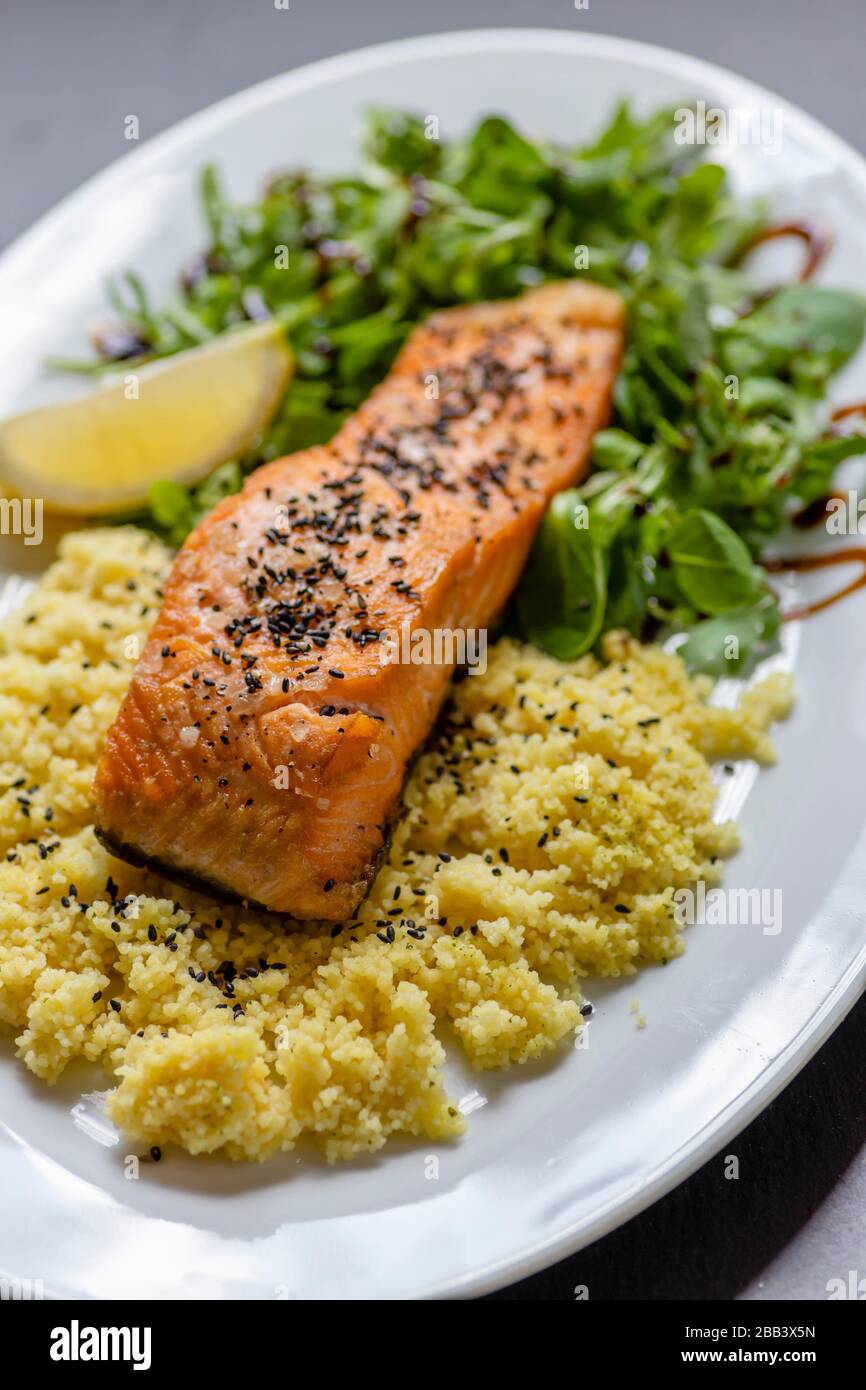 baked salmon with spinach salad and couscous Stock Photo Alamy