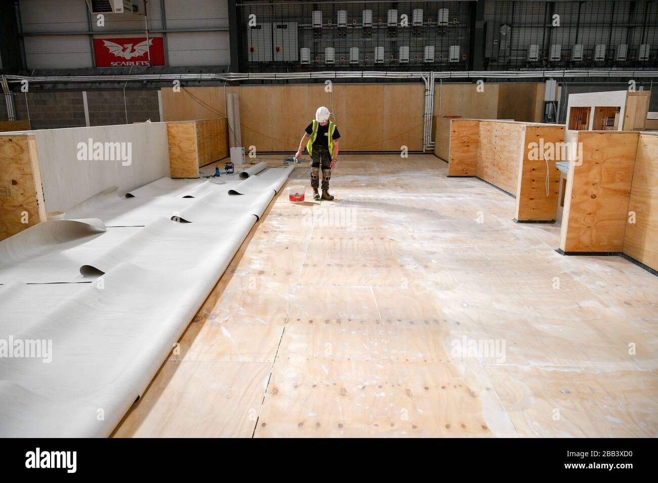 Contractor lays heavy duty medical grade vinyl onto wooden floor hires