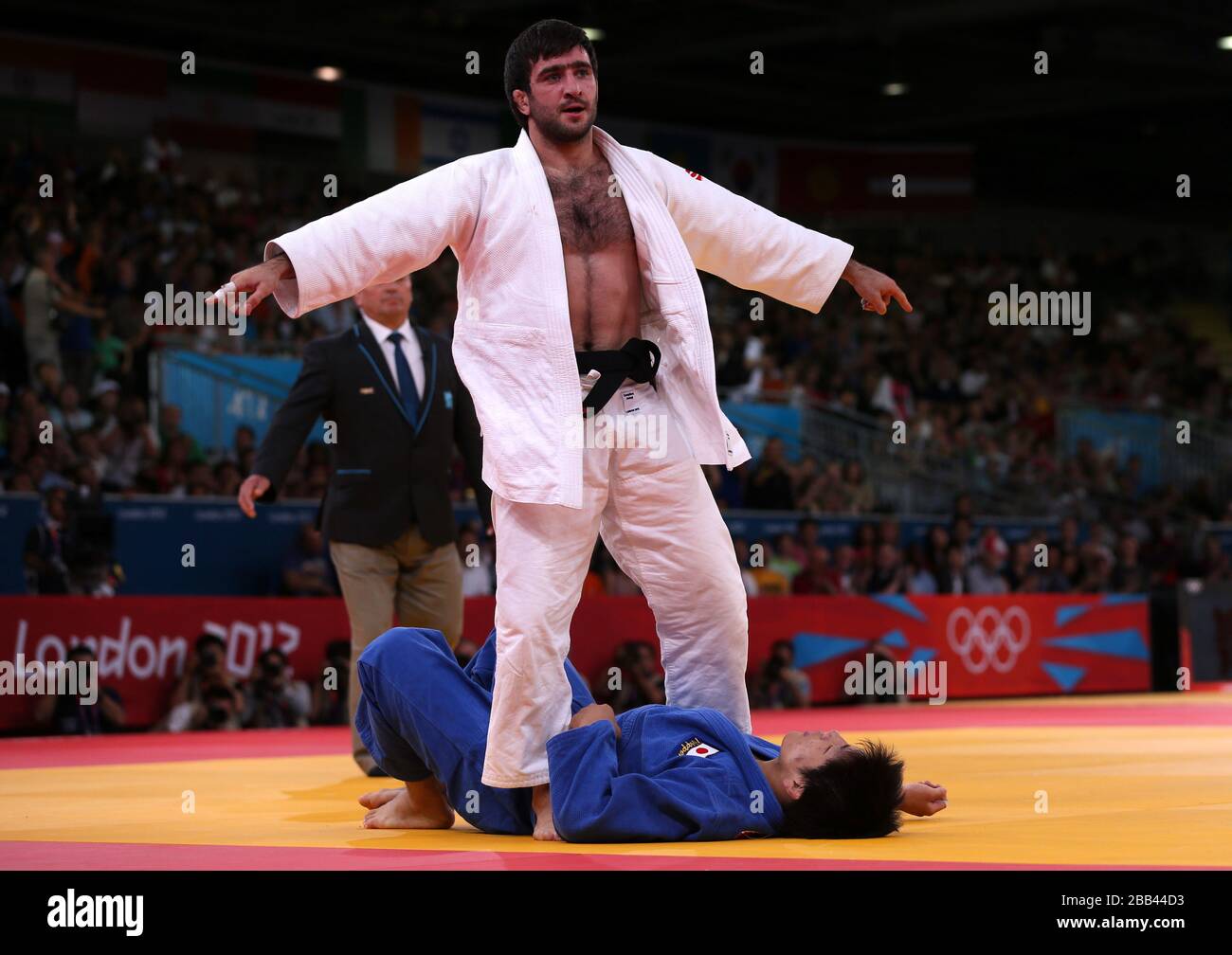 Russia's judo player Mansur Isaev stands as he celebrates after his