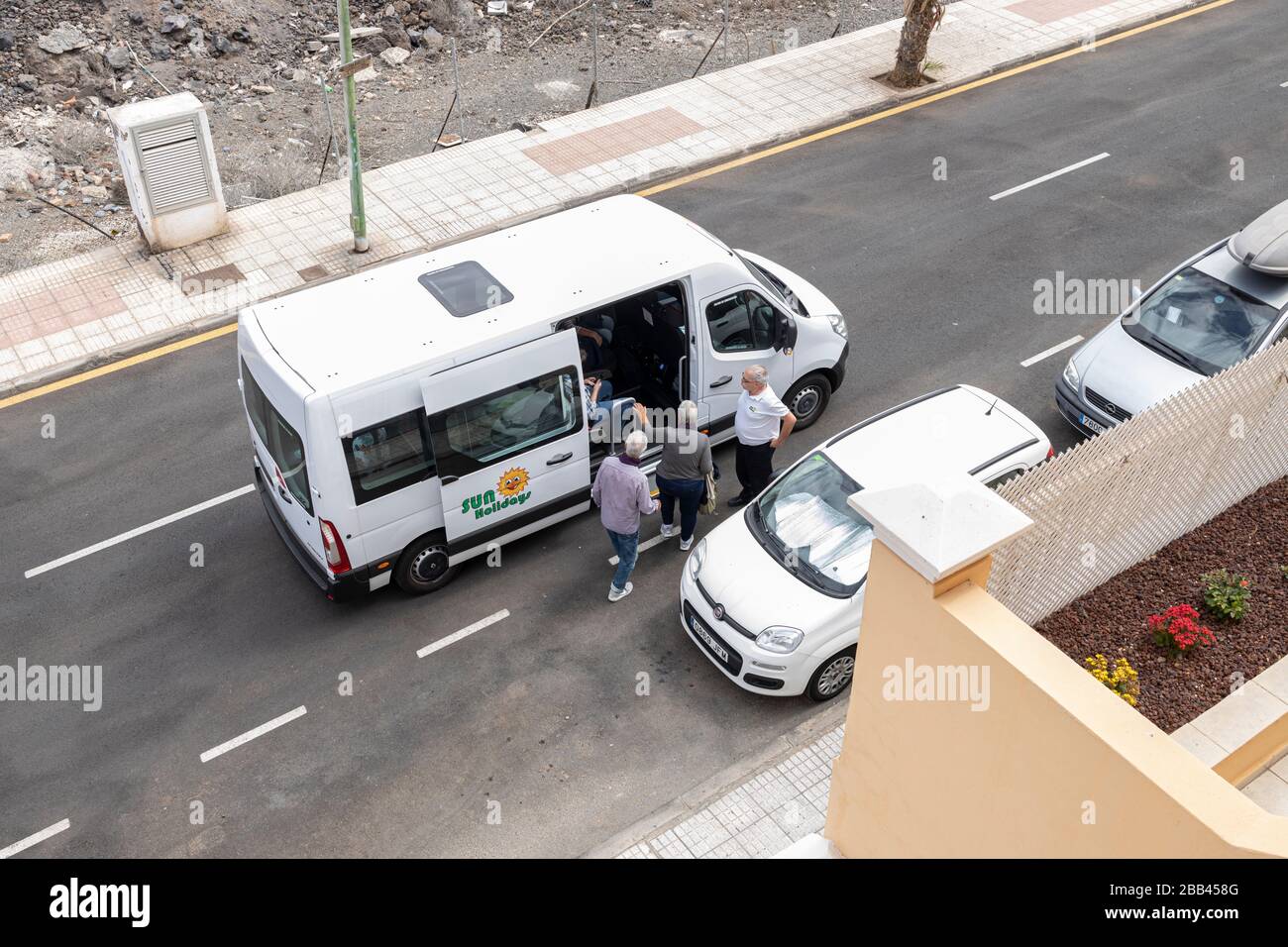 Tourists are picked up in a mini coach to go to the airport during the coronavirus lockdown. Playa San Juan, Tenerife, Canary Islands, Spain. Stock Photo