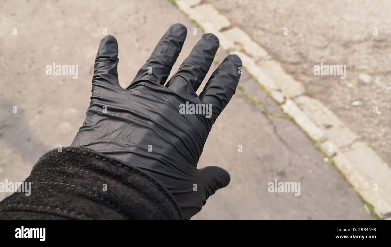 A black rubber glove that people wear because of the coronavirus. Stock Photo
