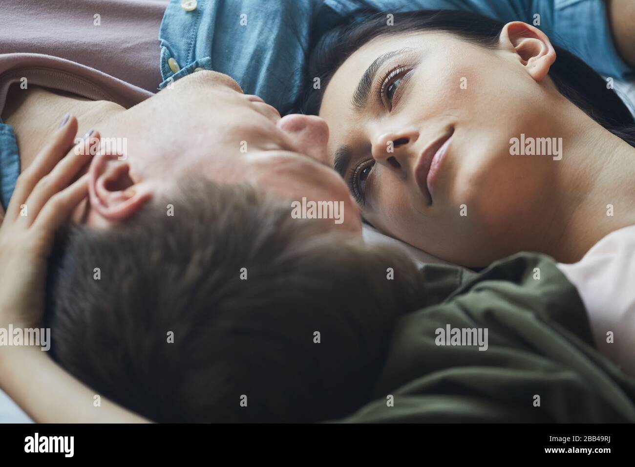 Close up of loving couple embracing tenderly while lying together, copy space Stock Photo