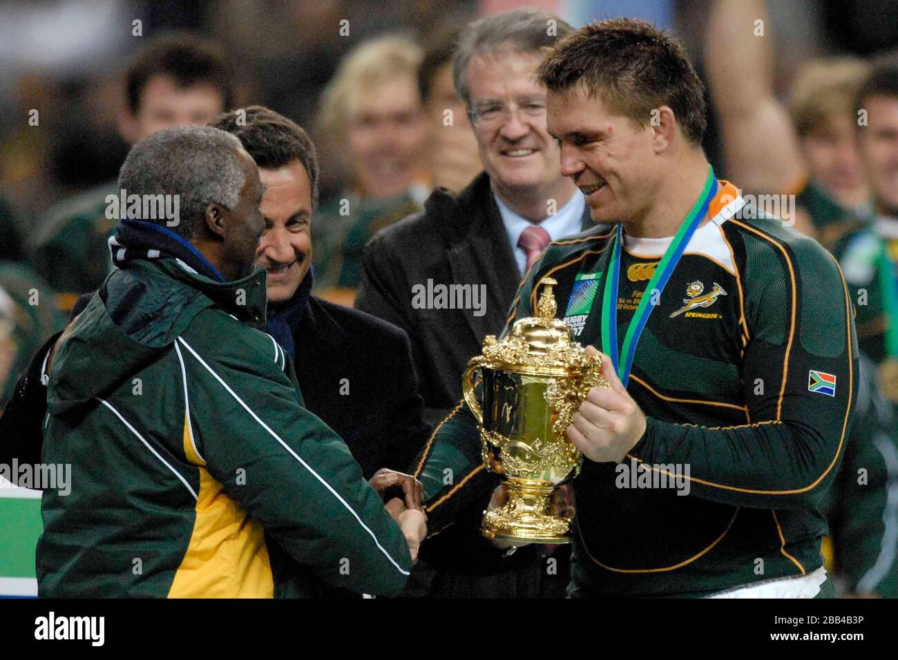 John Smit (South Africa, captain, right) holds the cup as he shakes hands with South African President Thabo Mvuyelwa Mbeki (left). Watched by French Stock Photo