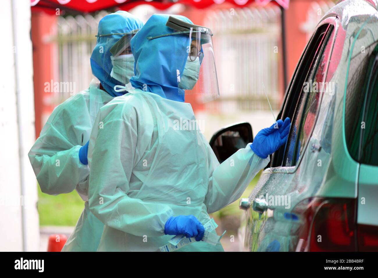 Kuala Lumpur, Malaysia. 30th Mar, 2020. A medical staff member takes the sample from a drive-through resident at a COVID-19 testing area of a hospital in Damansara near Kuala Lumpur, Malaysia, March 30, 2020. A total of 37 people have died of the COVID-19 in Malaysia as of Monday with 156 newly confirmed cases, bringing the total to 2,626, said the Health Ministry. Credit: Chong Voon Chung/Xinhua/Alamy Live News Stock Photo