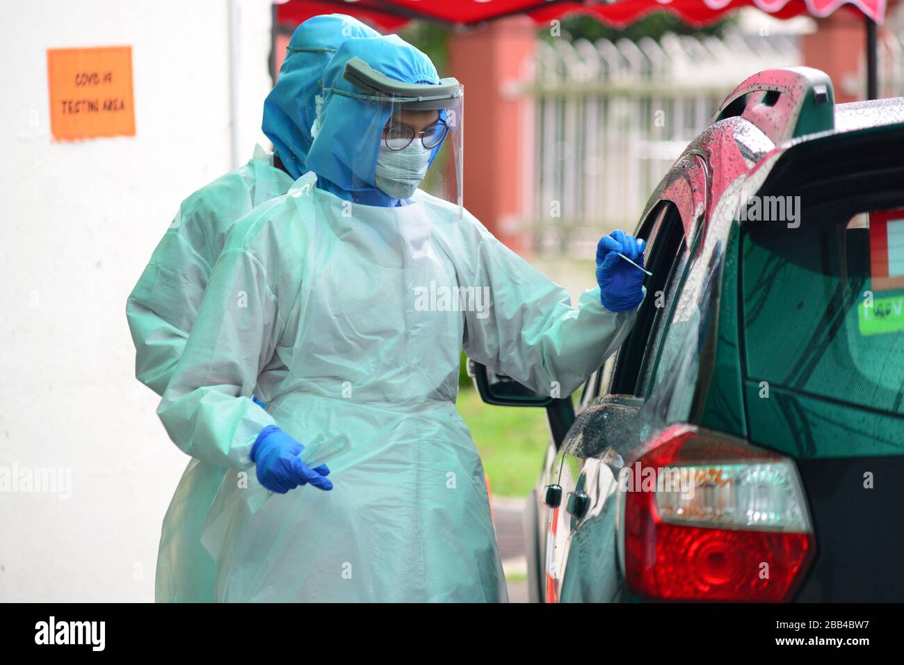 Kuala Lumpur, Malaysia. 30th Mar, 2020. A medical staff member takes the sample from a drive-through resident at a COVID-19 testing area of a hospital in Damansara near Kuala Lumpur, Malaysia, March 30, 2020. A total of 37 people have died of the COVID-19 in Malaysia as of Monday with 156 newly confirmed cases, bringing the total to 2,626, said the Health Ministry. Credit: Chong Voon Chung/Xinhua/Alamy Live News Stock Photo