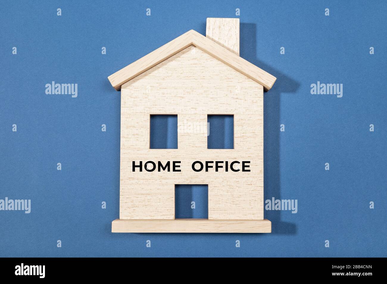 Home Office concept. Wooden house icon isolated on blue background Stock Photo