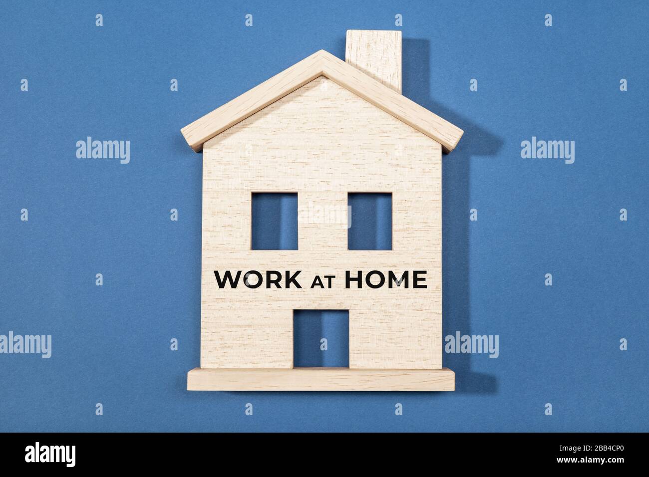 Work at home concept. Wooden house icon isolated on blue background Stock Photo