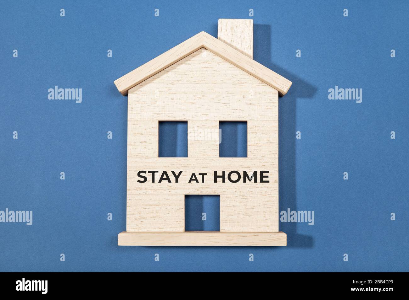 Stay at home concept. Wooden house icon isolated on blue background. Coronavirus outbreak advice Stock Photo