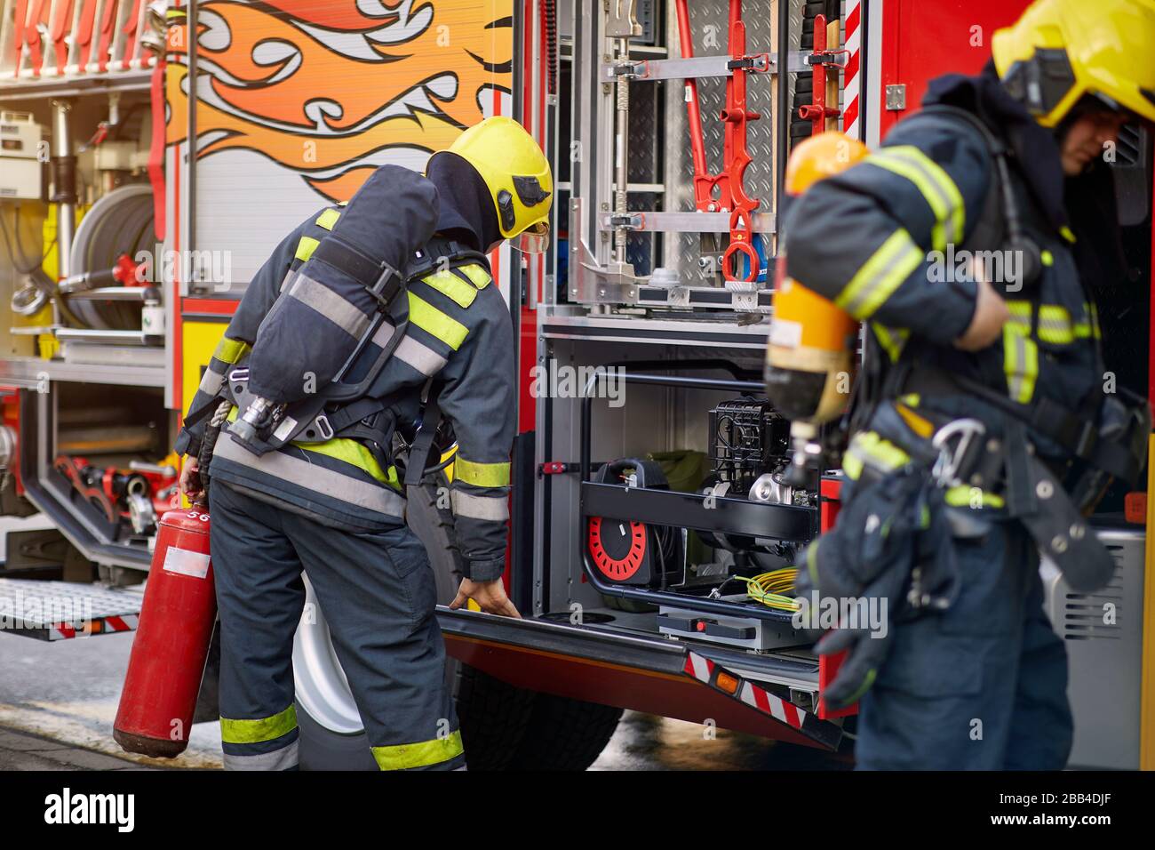 Fireman in uniform in front of fire truck going to rescue and protect. Emergancy , danger, servise concept. Stock Photo