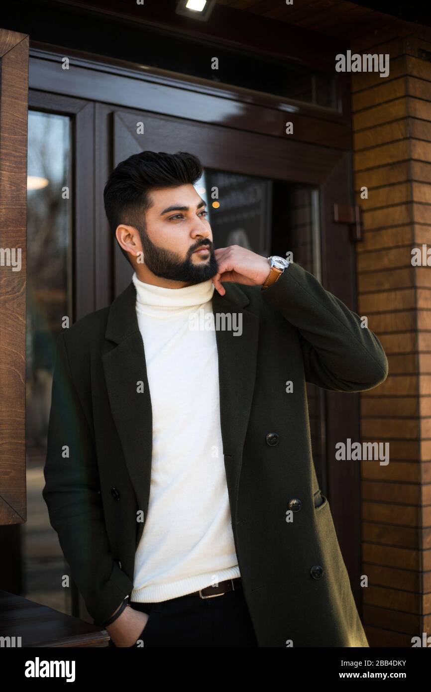 Portrait of fashionable well dressed bearded man at street. Young Indian man  in green coat posing outdoors looking away Stock Photo - Alamy
