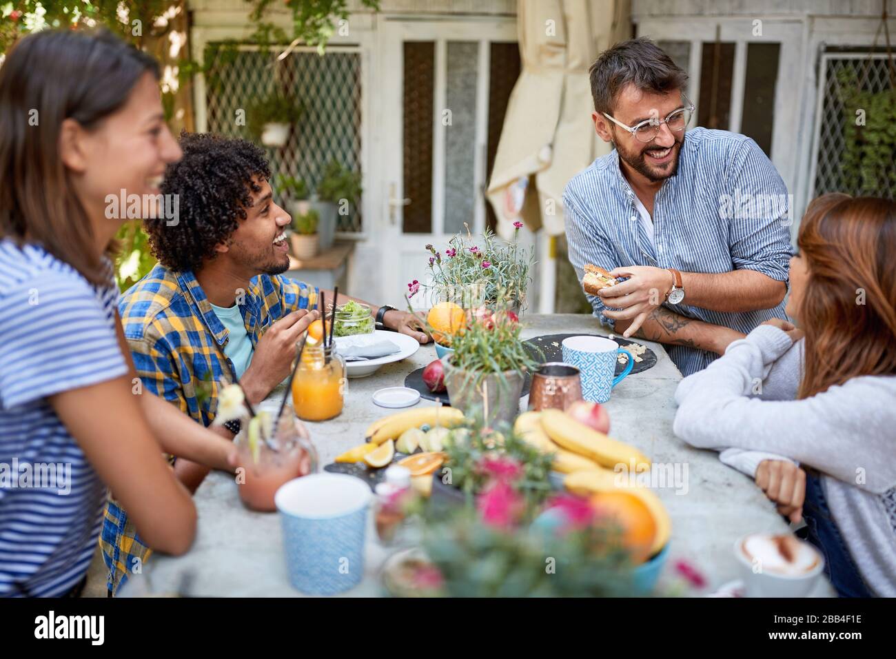 Group of young people enjoying in cafe at the table outdoor Stock Photo