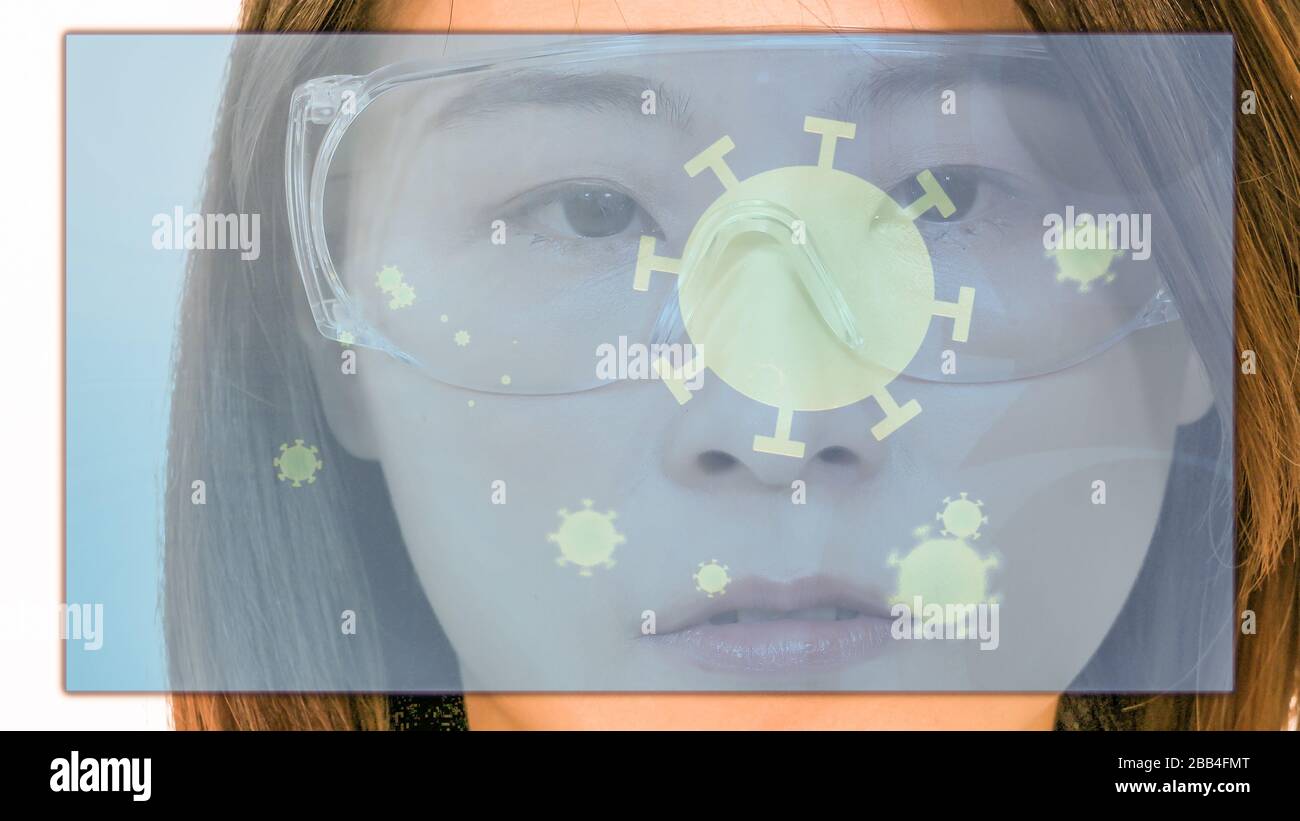 Female Asian American doctor looking at virtual medical screen with coronavirus cells, close-up Stock Photo