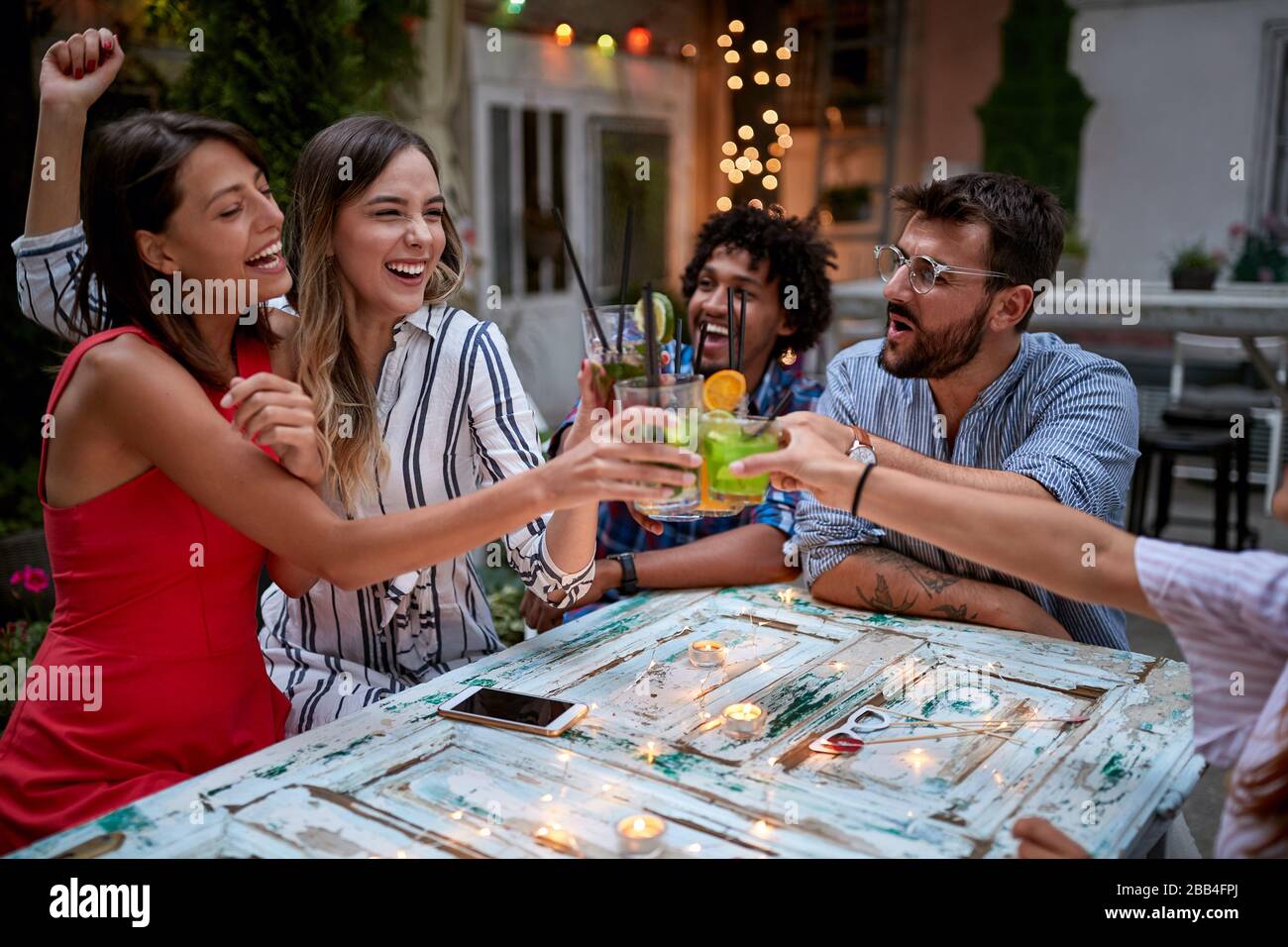 Happy friends toasting with female celebrant Stock Photo