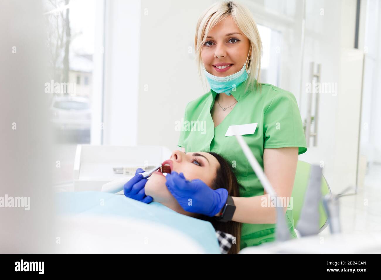 Portrait of a dentist doctor with a drill and a dental mirror in his ...